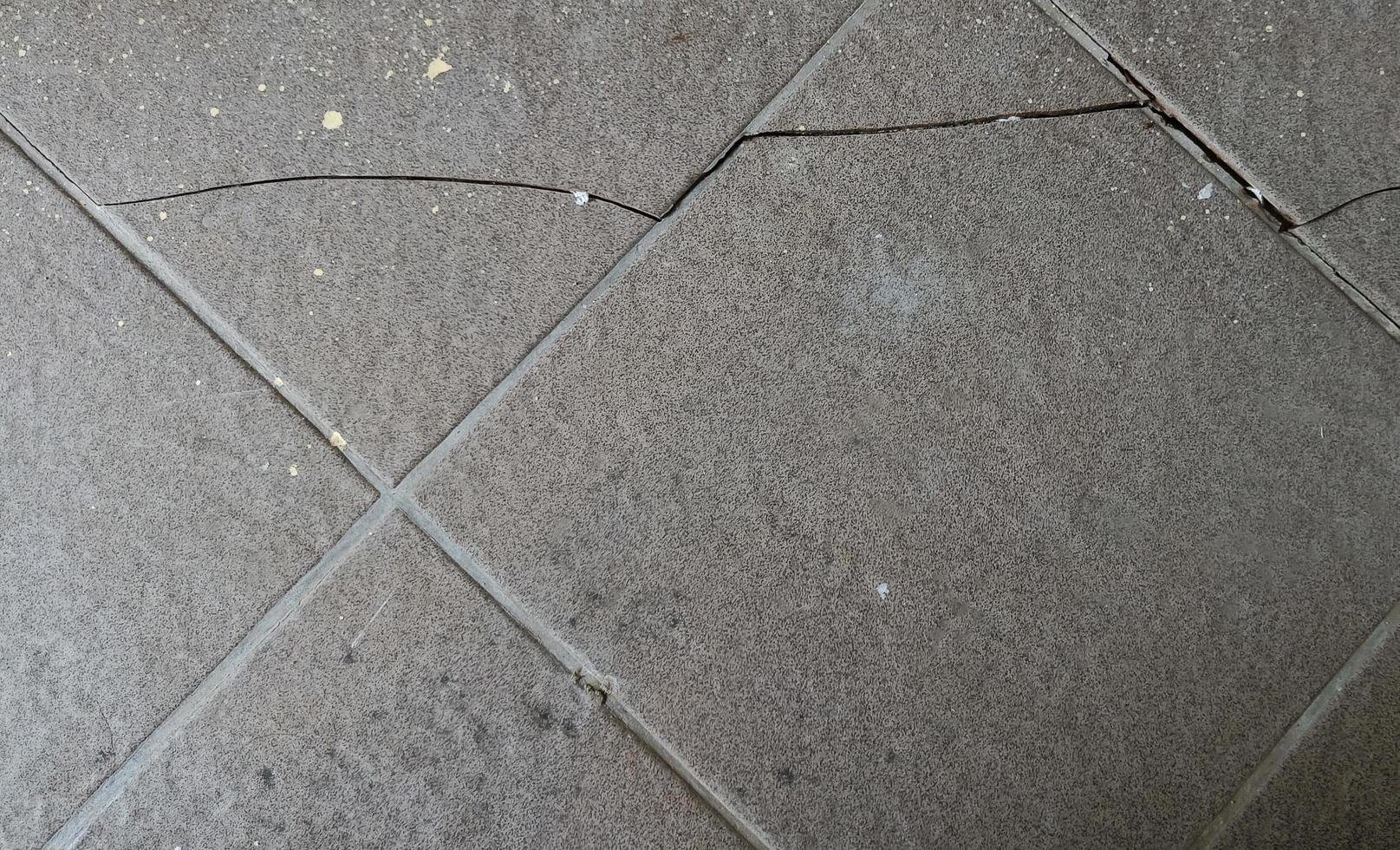 surface de carreaux de sol endommagés fissurés cassés nécessitant une réparation de l'ancien fond de texture. photo