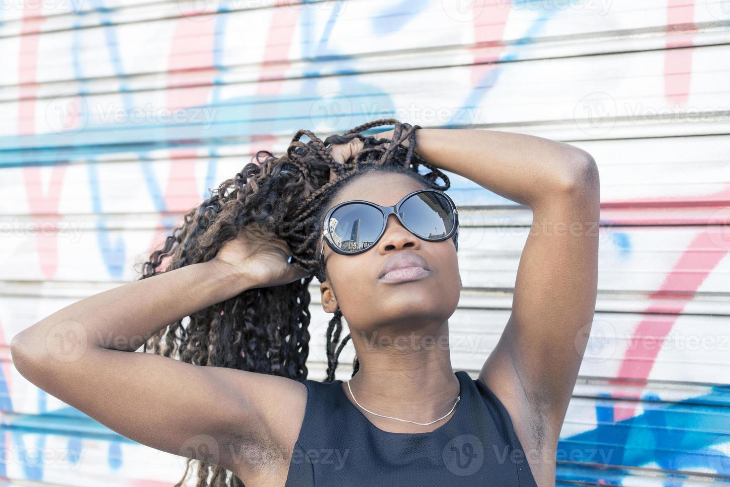 portrait urbain de la belle femme africaine avec des lunettes de soleil, coiffure. photo