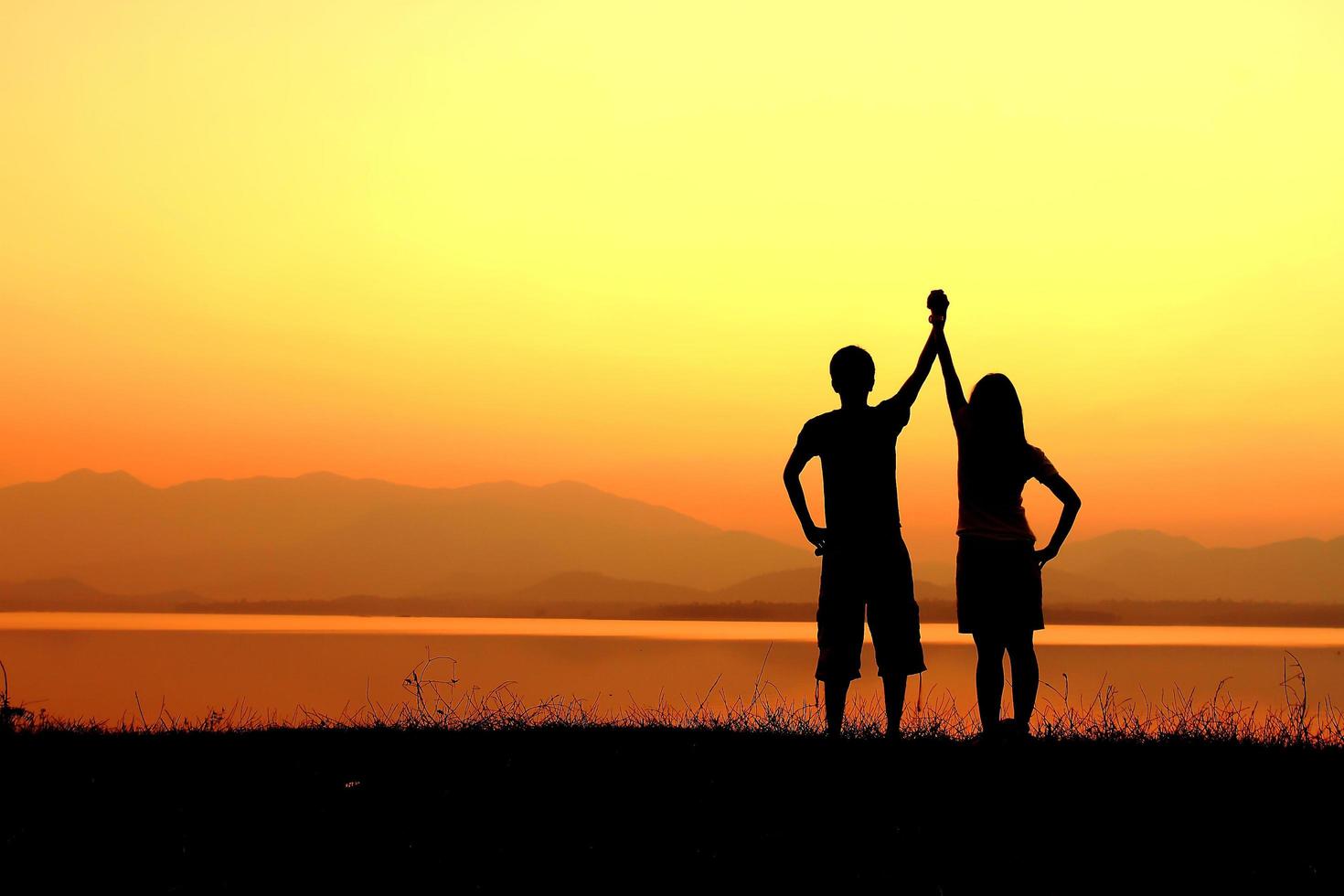 silhouette de couple sur la plage au coucher du soleil photo