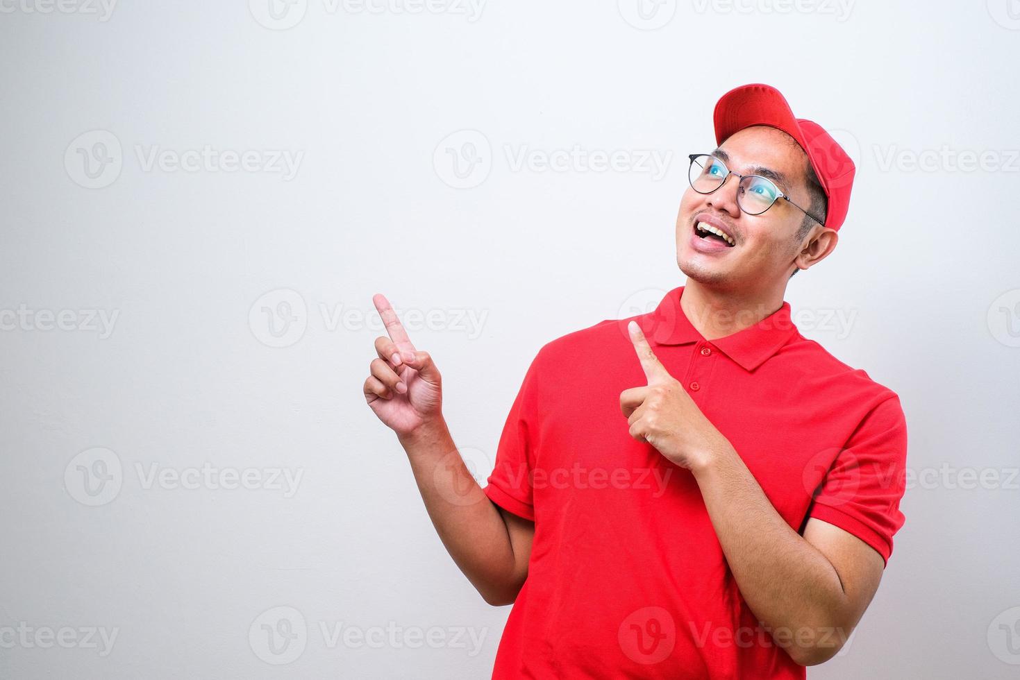 jeune beau livreur chinois pointant avec la main et le doigt sur le côté en regardant la caméra. photo