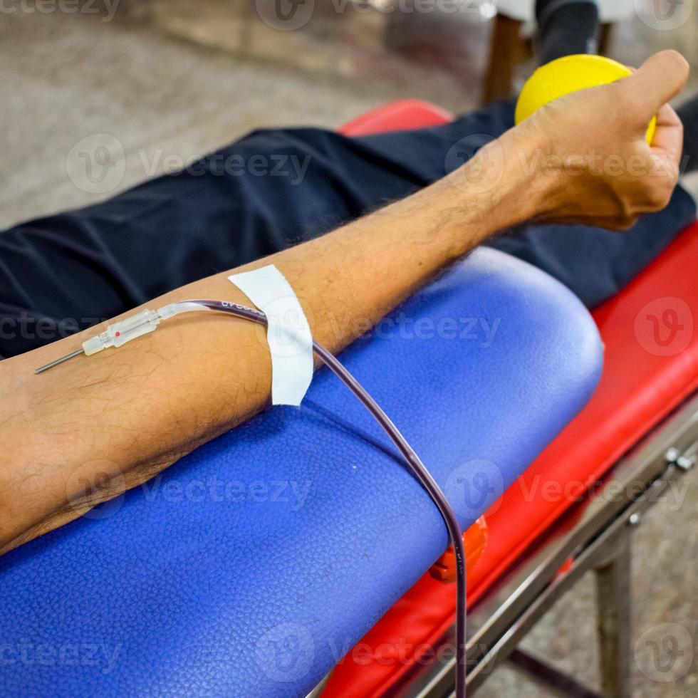 donneur de sang au camp de don de sang tenu avec une balle gonflable tenant dans la main au temple balaji, vivek vihar, delhi, inde, image pour la journée mondiale du don de sang le 14 juin de chaque année, camp de don de sang photo