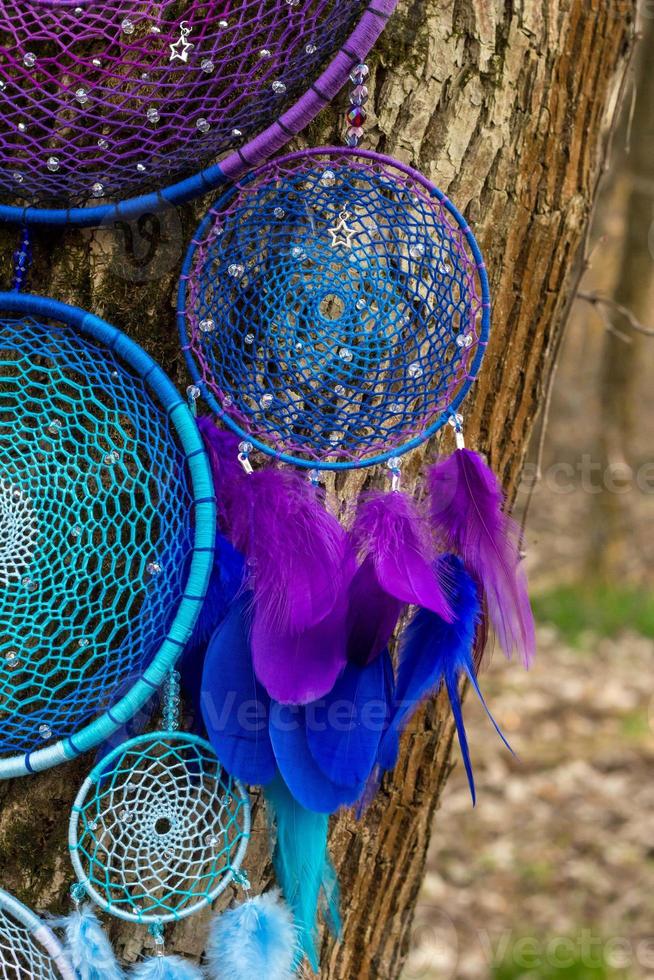 attrape-rêves fait à la main avec des fils de plumes et des cordes de perles suspendues photo