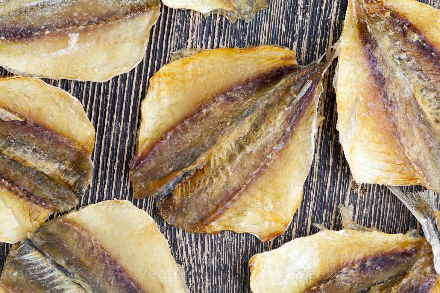 petits poissons séchés et dépecés sur une table en bois photo