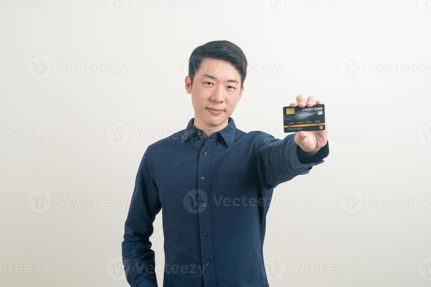 jeune homme asiatique tenant une carte de crédit photo