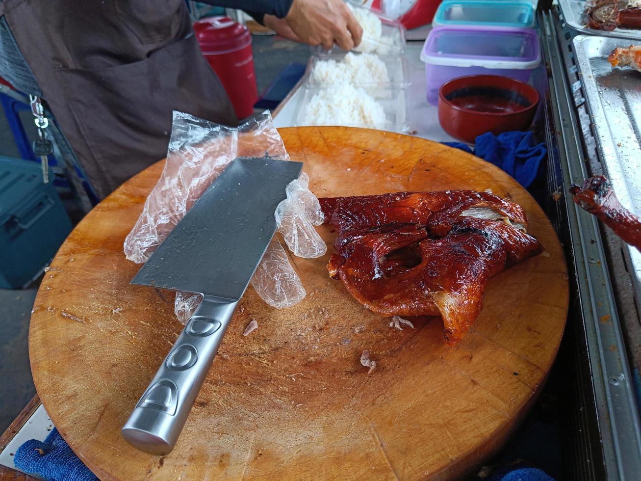 griller le canard sur une planche à découper en bois. magasin de riz au canard photo