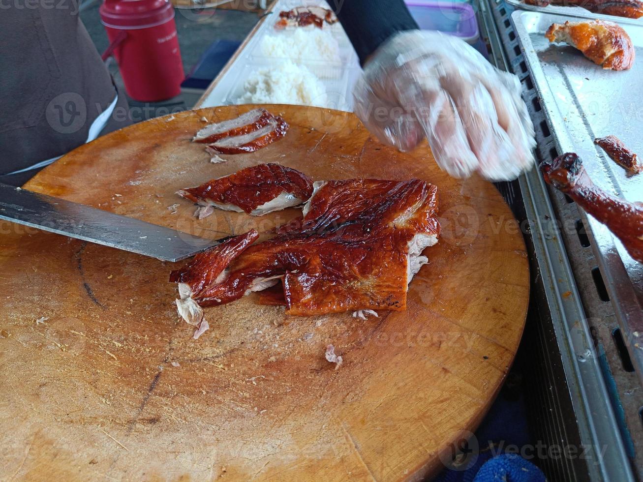 canard rôti sur une planche à découper en bois. magasin de riz au canard photo