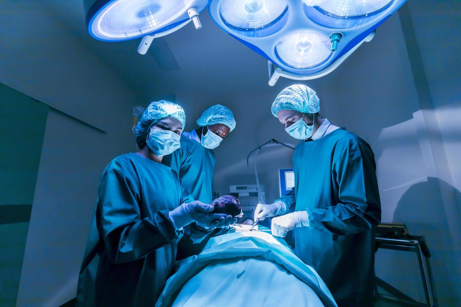 une équipe de médecins chirurgiens effectue une opération de chirurgie cardiaque pour un patient d'un donneur d'organes afin de sauver plus de vie dans la salle d'opération d'urgence photo