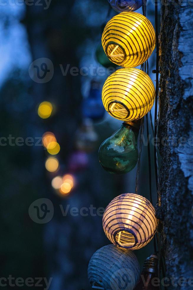 guirlande de lumières en forme d'ampoule. garden-party ou soirée de détente en plein air. ambiance légère avec bokeh photo