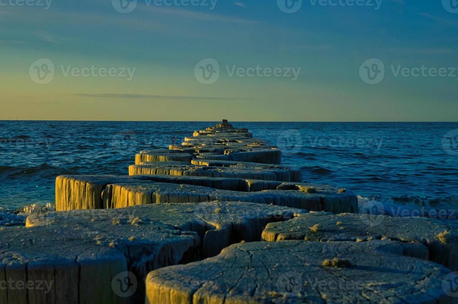 épis sur la plage de la mer baltique à zingst. les vagues se brisent sur le bois photo