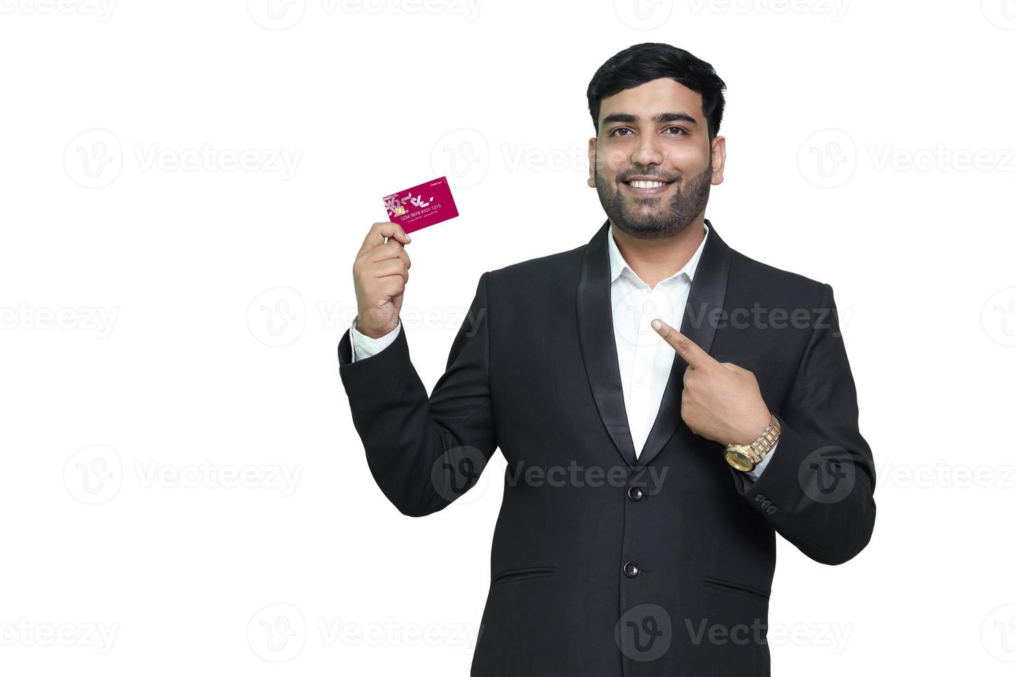 jeune homme souriant en pointant sur la carte de crédit. photo