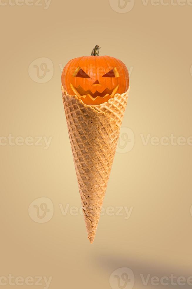 citrouilles d'halloween avec glace à cône sur fond beige pastel. idée créative concept minimal. dessert sucré d'halloween. photo