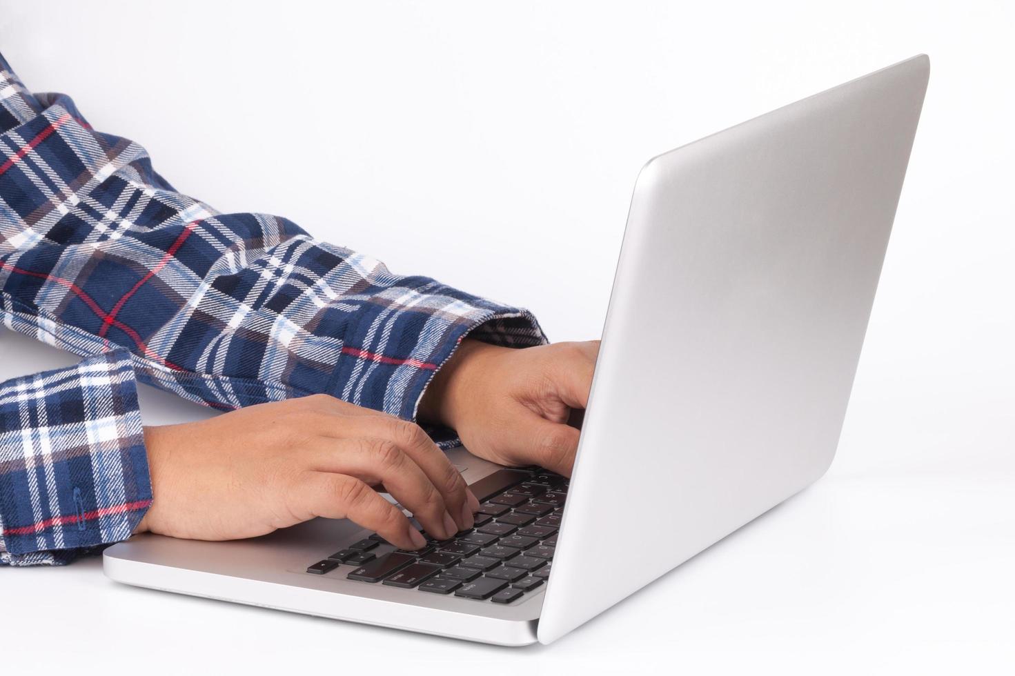 Mains tapant sur le clavier d'un ordinateur portable sur fond blanc photo