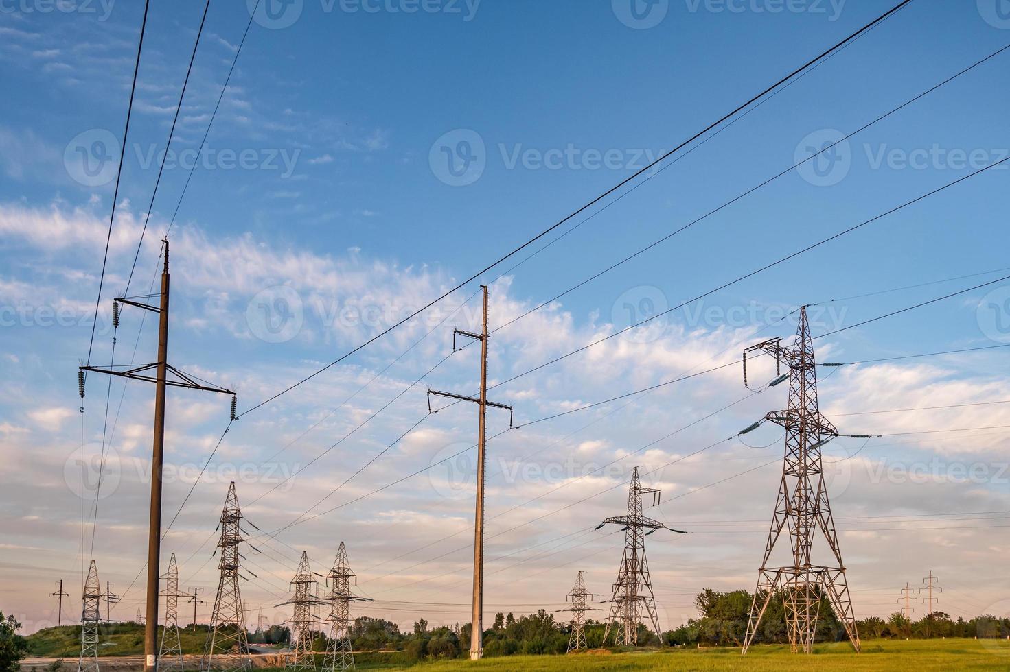 silhouette des pylônes électriques à haute tension sur fond de beaux nuages du soir photo