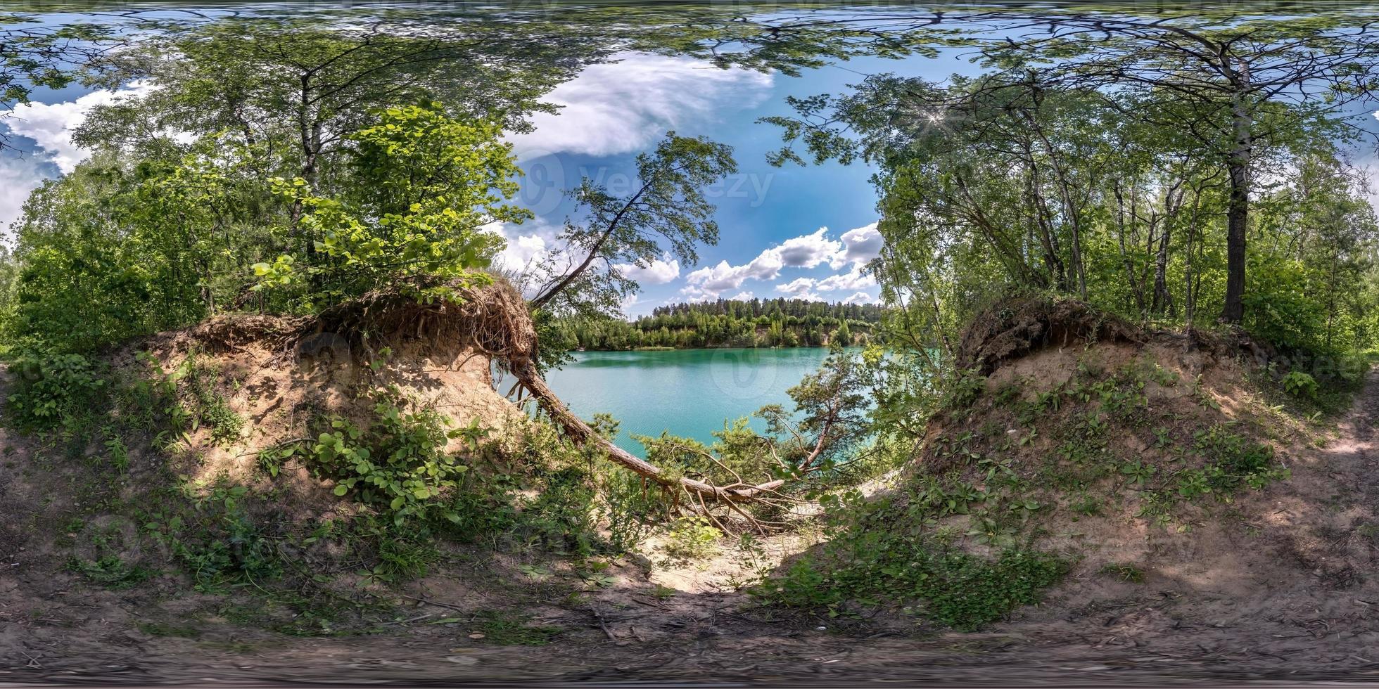 panorama hdri sphérique complet et harmonieux vue d'angle à 360 degrés dans la forêt de pins avec des racines d'arbres maladroites sur la côte d'un immense lac vert en projection équirectangulaire, prêt vr ar contenu de réalité virtuelle photo