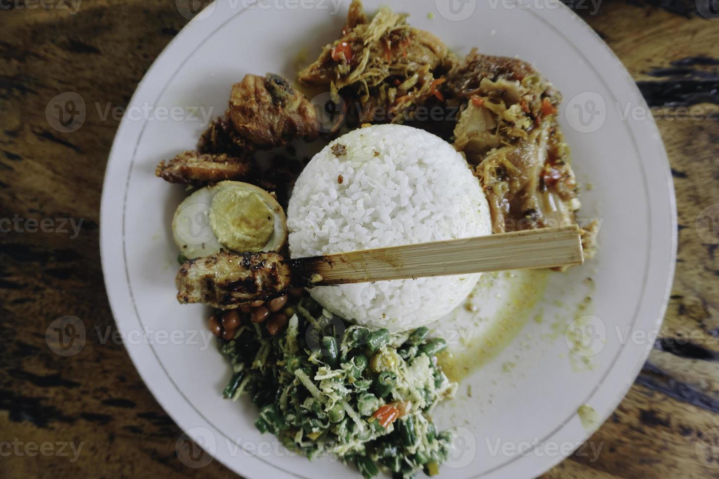 nasi campur ayam betutu. poulet rôti balinais farci de feuilles de manioc. accompagné de riz cuit à la vapeur, sate lilit, jukut antungan, lawar nangka et sambal matah. photo