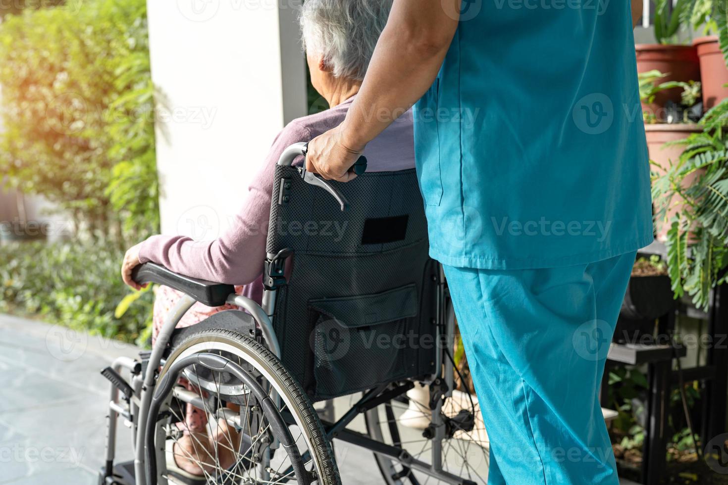 aide et soins des soignants asiatiques âgées ou âgées vieille dame patiente assise dans un fauteuil roulant sur une rampe à l'hôpital de soins infirmiers, concept médical solide et sain photo