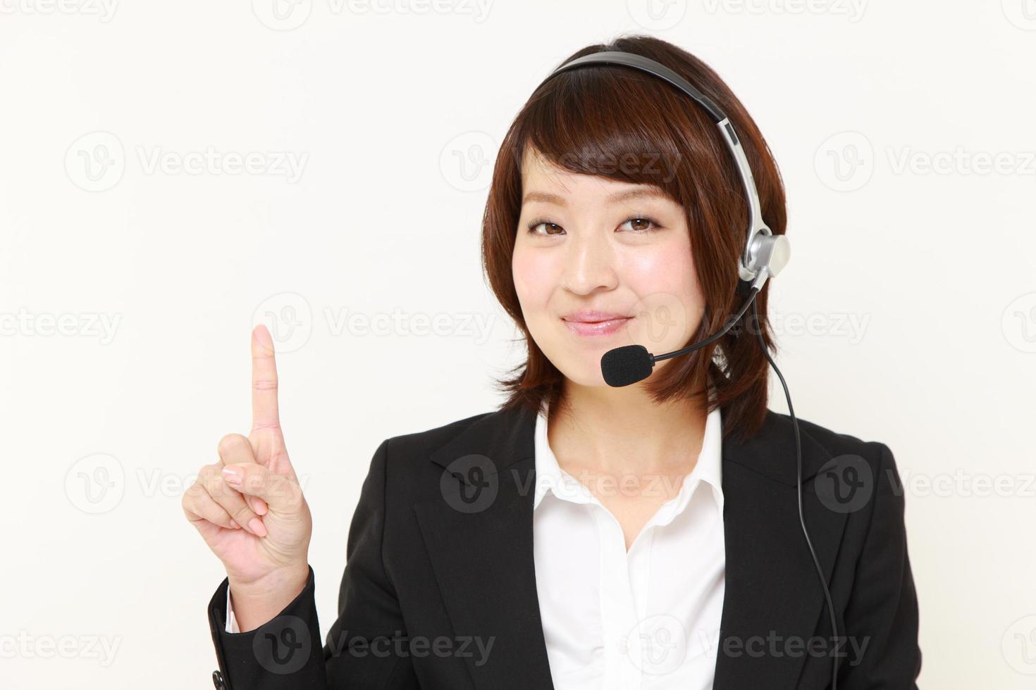 femme d'affaires japonaise de centre d'appel présentant et montrant quelque chose photo
