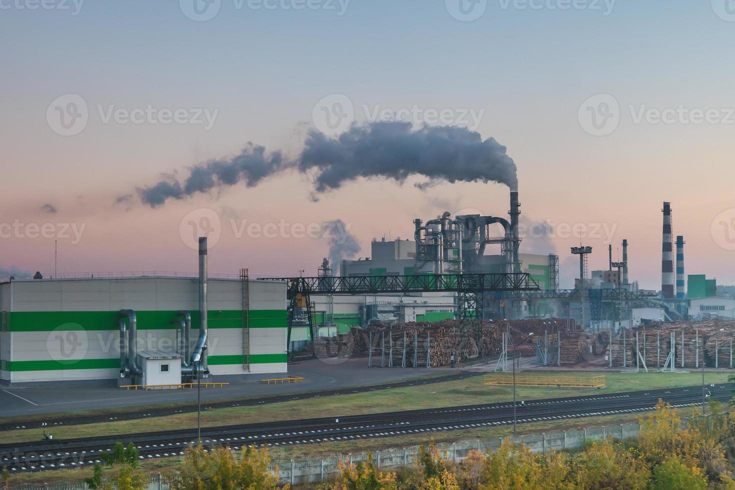 tuyaux de la scierie de l'usine de menuiserie à l'aube du matin. notion de pollution atmosphérique. paysage industriel pollution environnementale déchets de centrale thermique photo