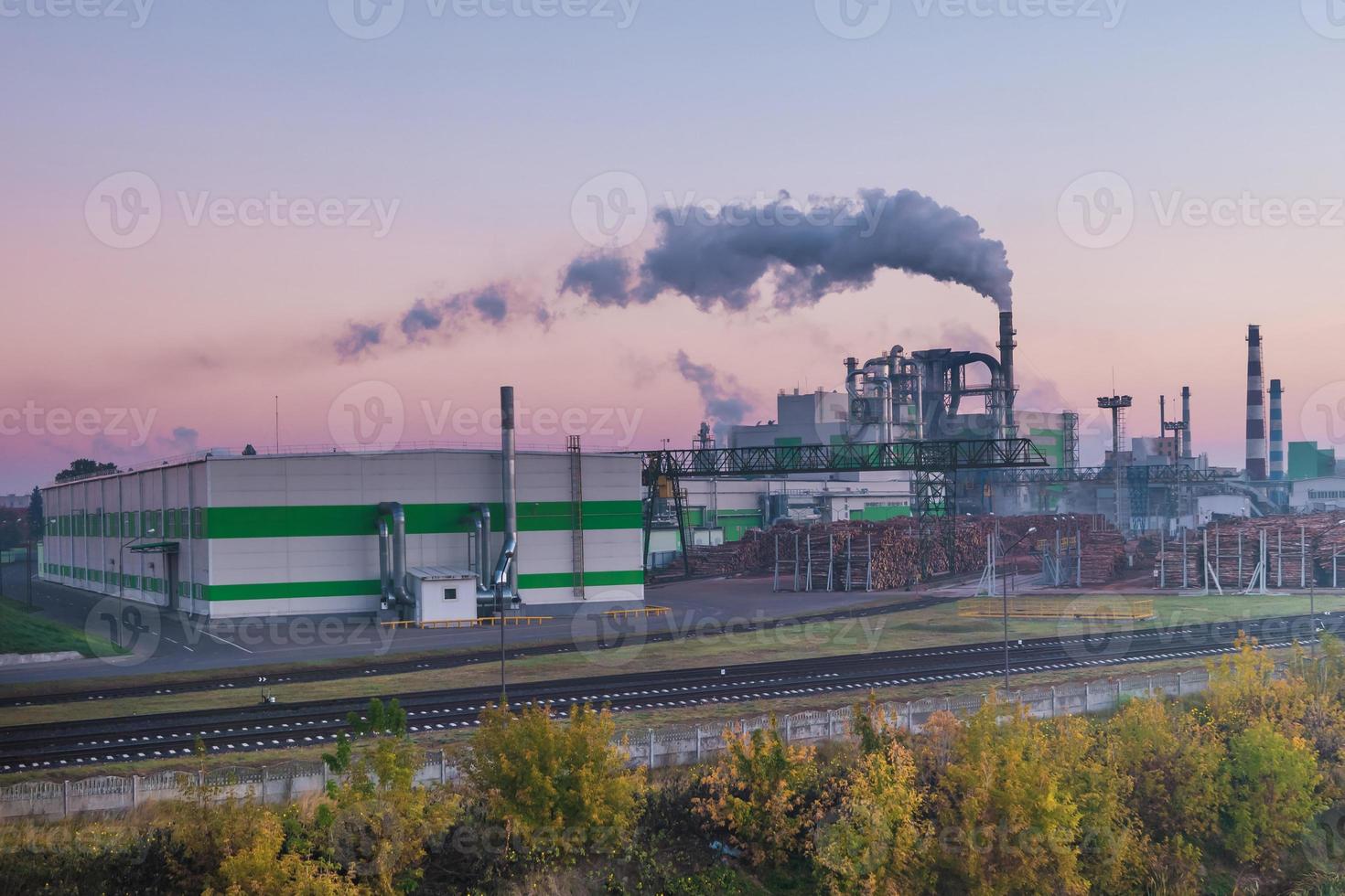 tuyaux de la scierie de l'usine de menuiserie à l'aube du matin. notion de pollution atmosphérique. paysage industriel pollution environnementale déchets de centrale thermique photo