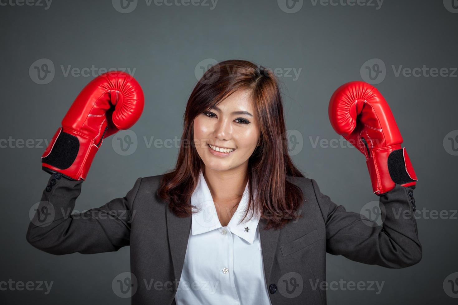 femme d'affaires asiatique avec un gant de boxe montre ses poings photo