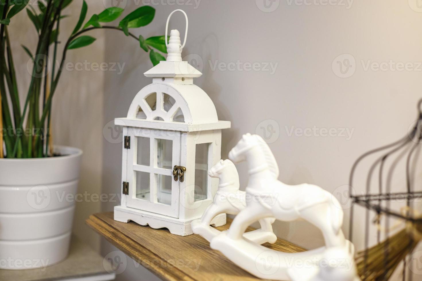 jouets de décoration intérieure. lanternes en bois décoratives blanches et chevaux en céramique dans un intérieur coûteux photo
