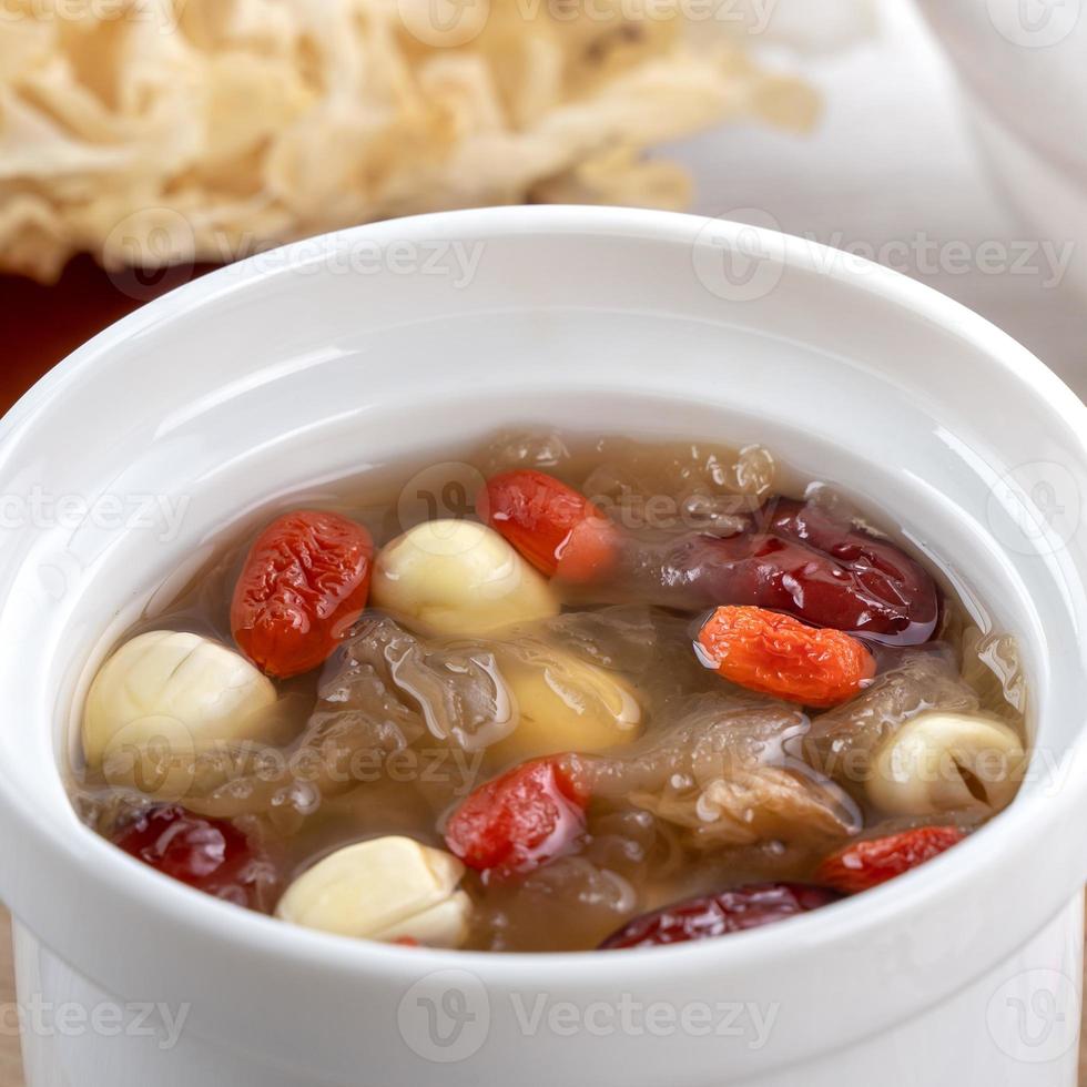 gros plan d'une douce soupe de champignons blanc neige avec graines de lotus, dattes rouges chinoises et goji. photo