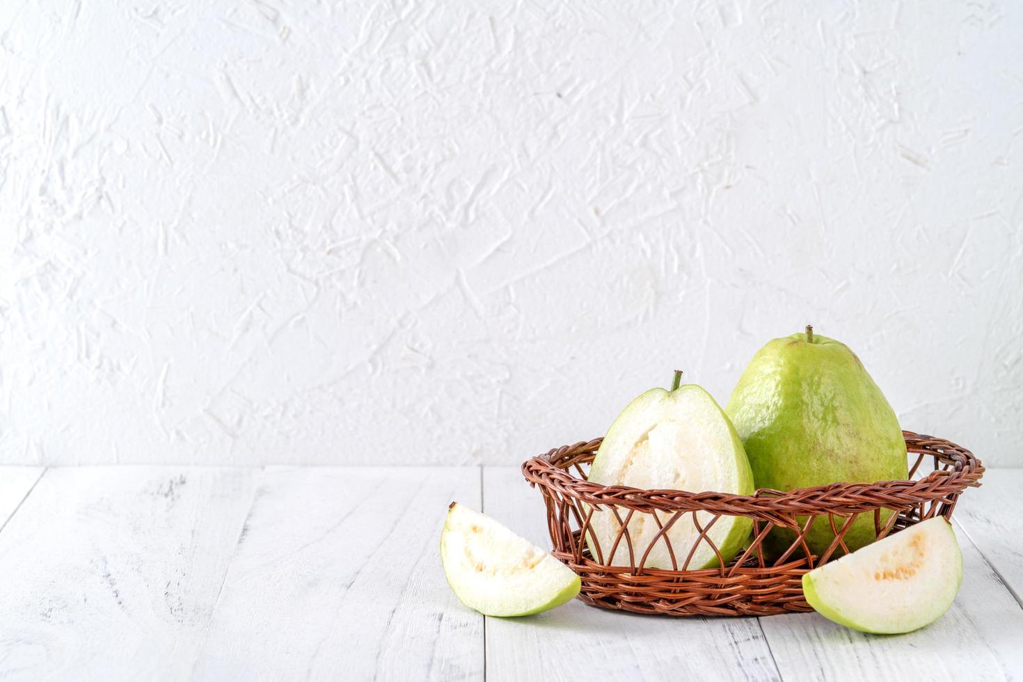 délicieux fruits de goyave sur fond de table en bois blanc avec espace de copie. photo