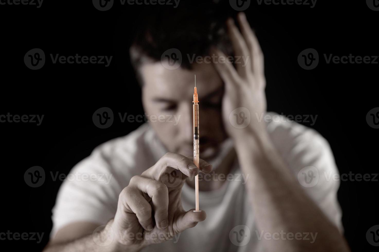 Homme toxicomane avec une seringue d'héroïne ou de cocaïne déprimée photo