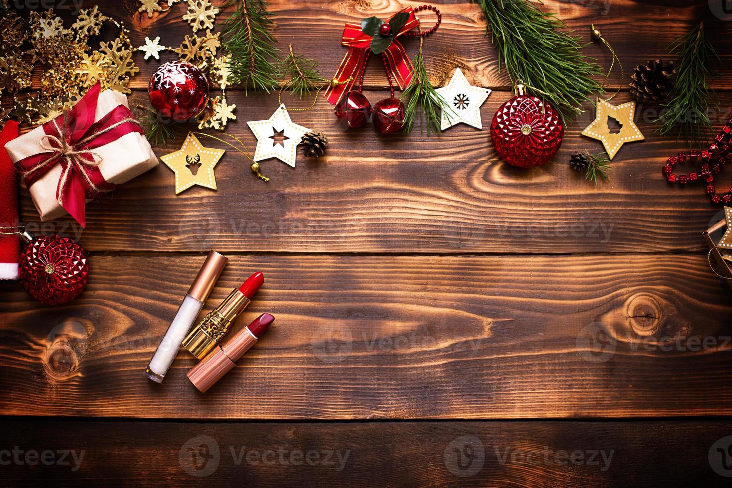 rouge à lèvres et brillant à lèvres et paupières sur un fond en bois dans le décor de noël. maquillage de fêtes pour le nouvel an, cadeau, shopping, envies de femmes. espace pour le texte, mise à plat photo