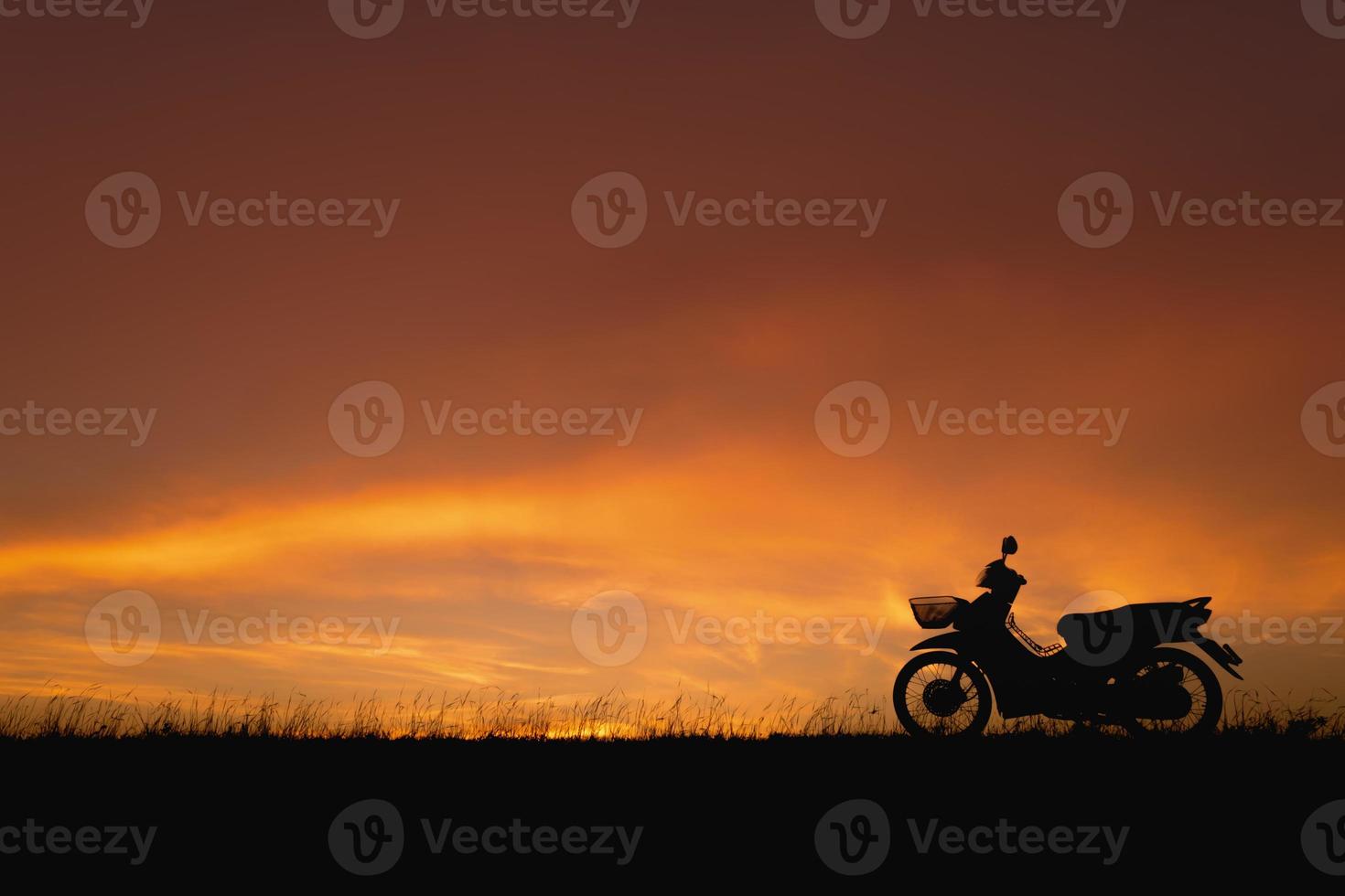 ciel coucher de soleil orange. moto silhouette en toile de fond paysage coucher de soleil photo