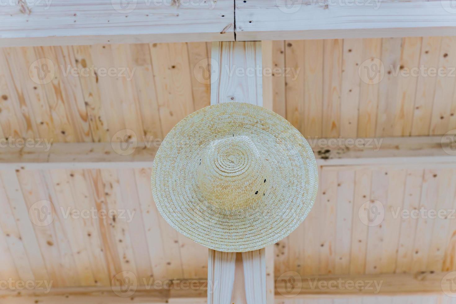 chapeau de paille wooman suspendu à un poteau en bois photo