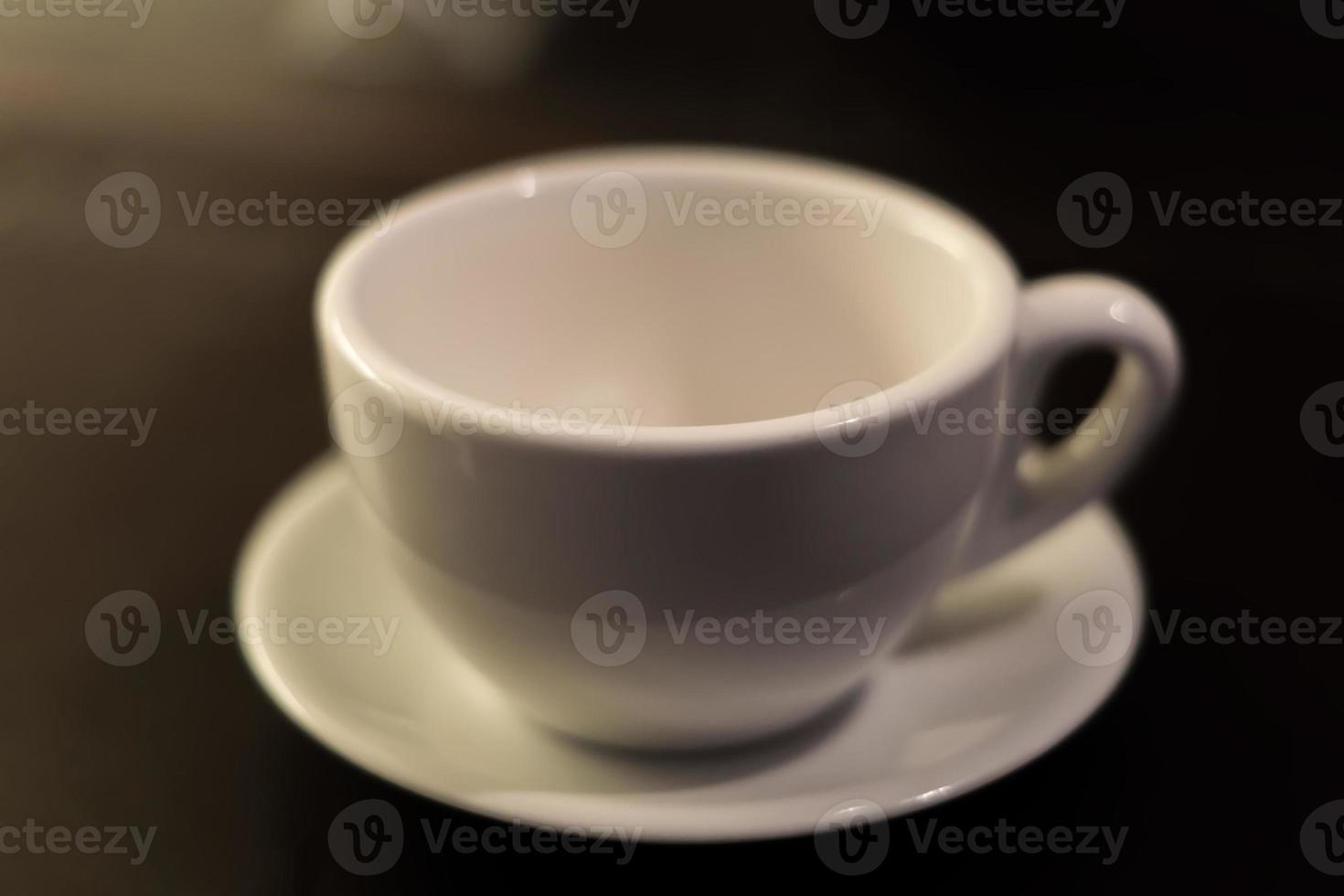 tasse à thé blanche et soucoupe sur table. mise au point douce photo