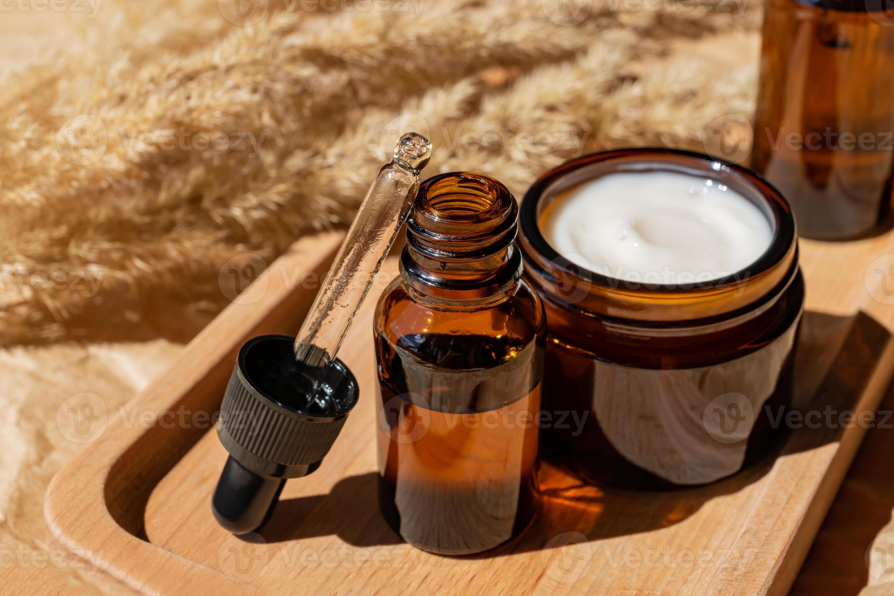 flacon cosmétique en verre foncé avec compte-gouttes sur fond gris avec  pierres et feuilles tropicales. concept de cosmétiques naturels, huiles  essentielles naturelles et produits de soins de la peau 11035617 Photo de