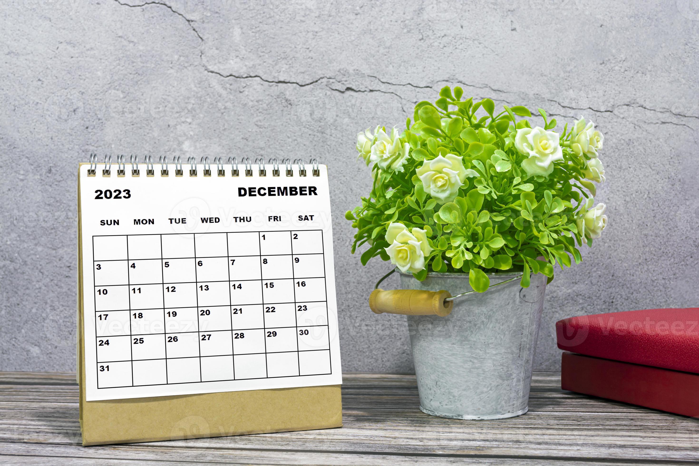 calendrier de bureau de décembre 2023 sur un bureau en bois avec plante en  pot et livres. 11198316 Photo de stock chez Vecteezy