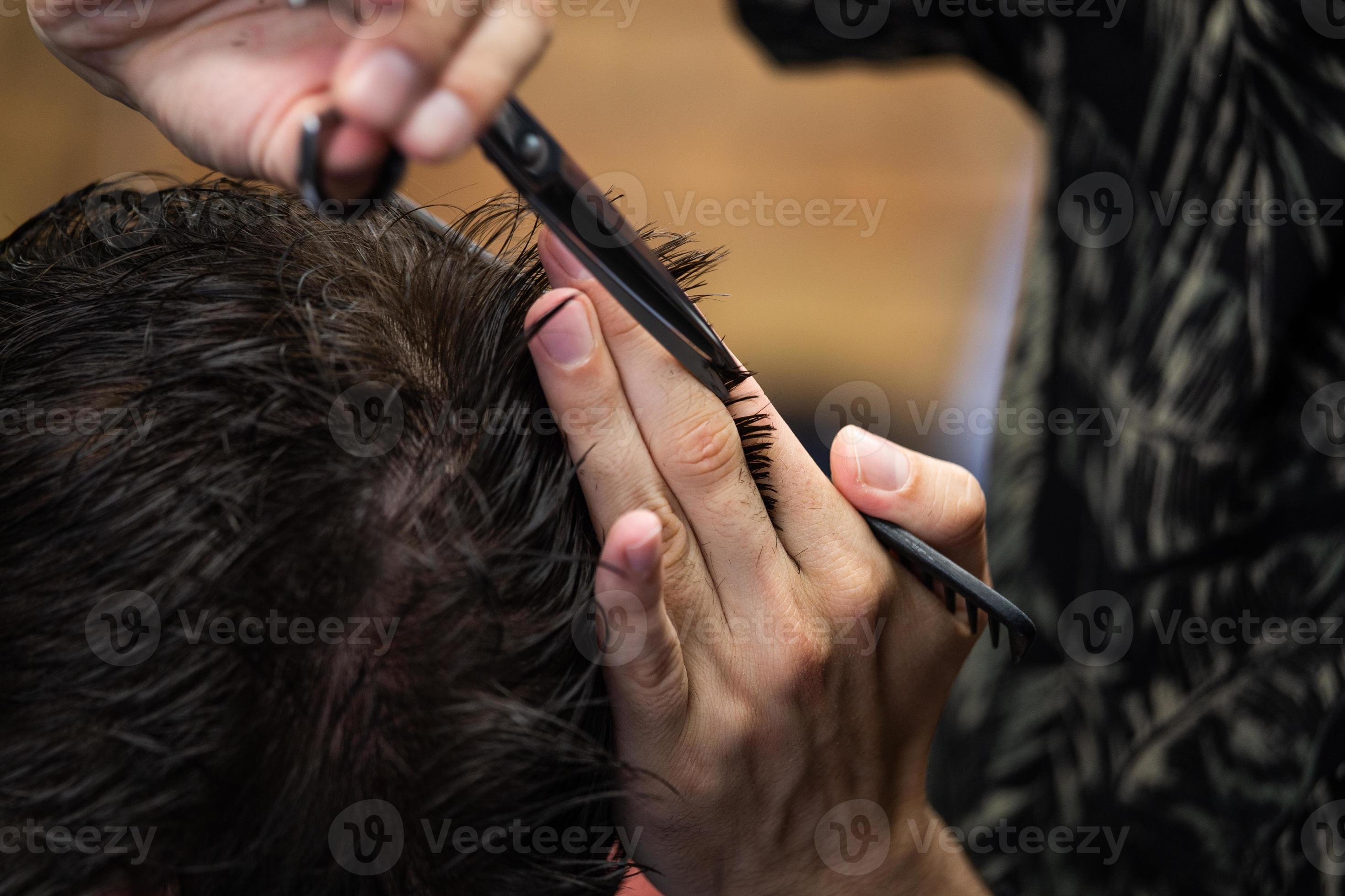 Coiffeur Faisant La Coupe De Cheveux De La Barbe à L'aide D'un Peigne Et De  Ciseaux Pour Un Jeune Homme Séduisant Dans Un Salon De Coiffure Pour Hommes