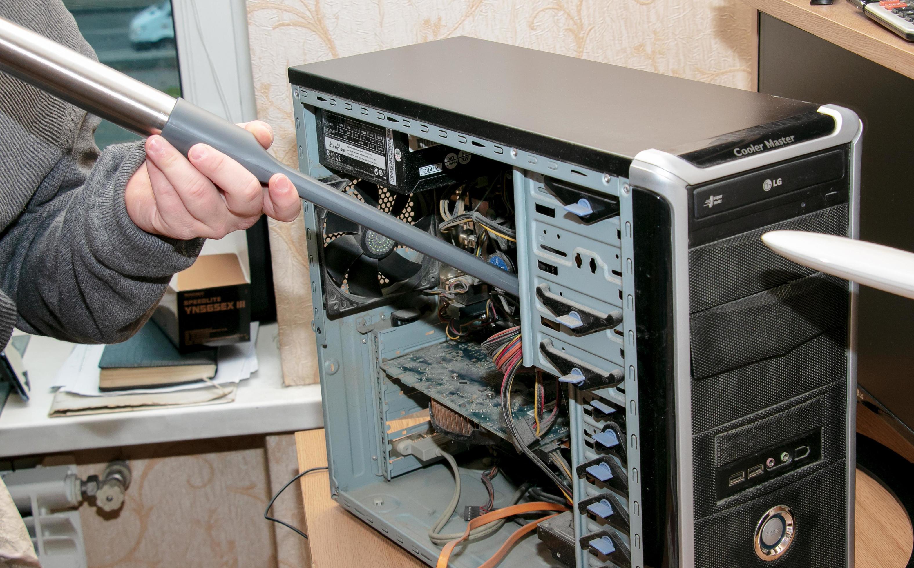 nettoyer l'unité centrale d'un ordinateur de bureau de la poussière à  l'aide d'un aspirateur. 12348266 Photo de stock chez Vecteezy