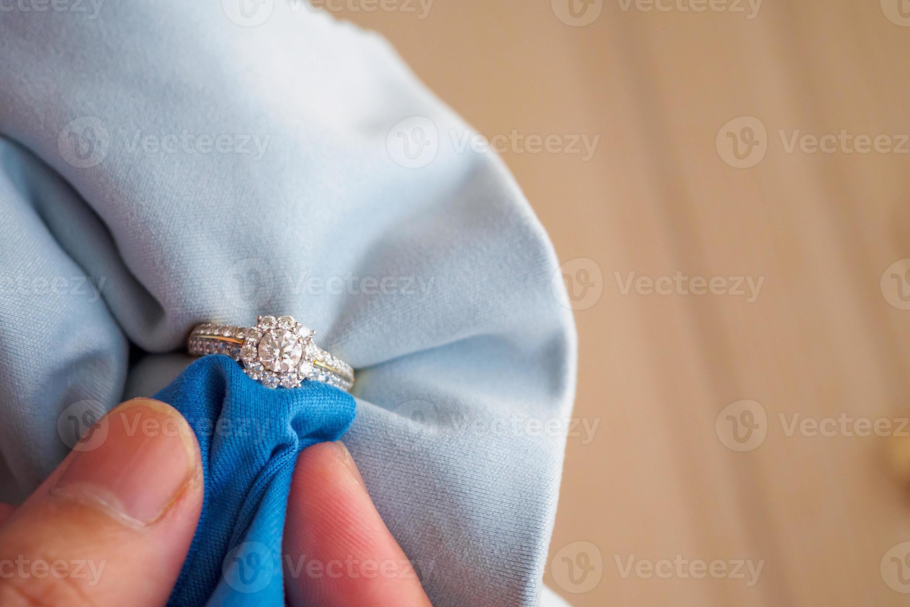 bijoutier polissage et nettoyage à la main bijoux bague en diamant avec  tissu en microfibre 12603016 Photo de stock chez Vecteezy