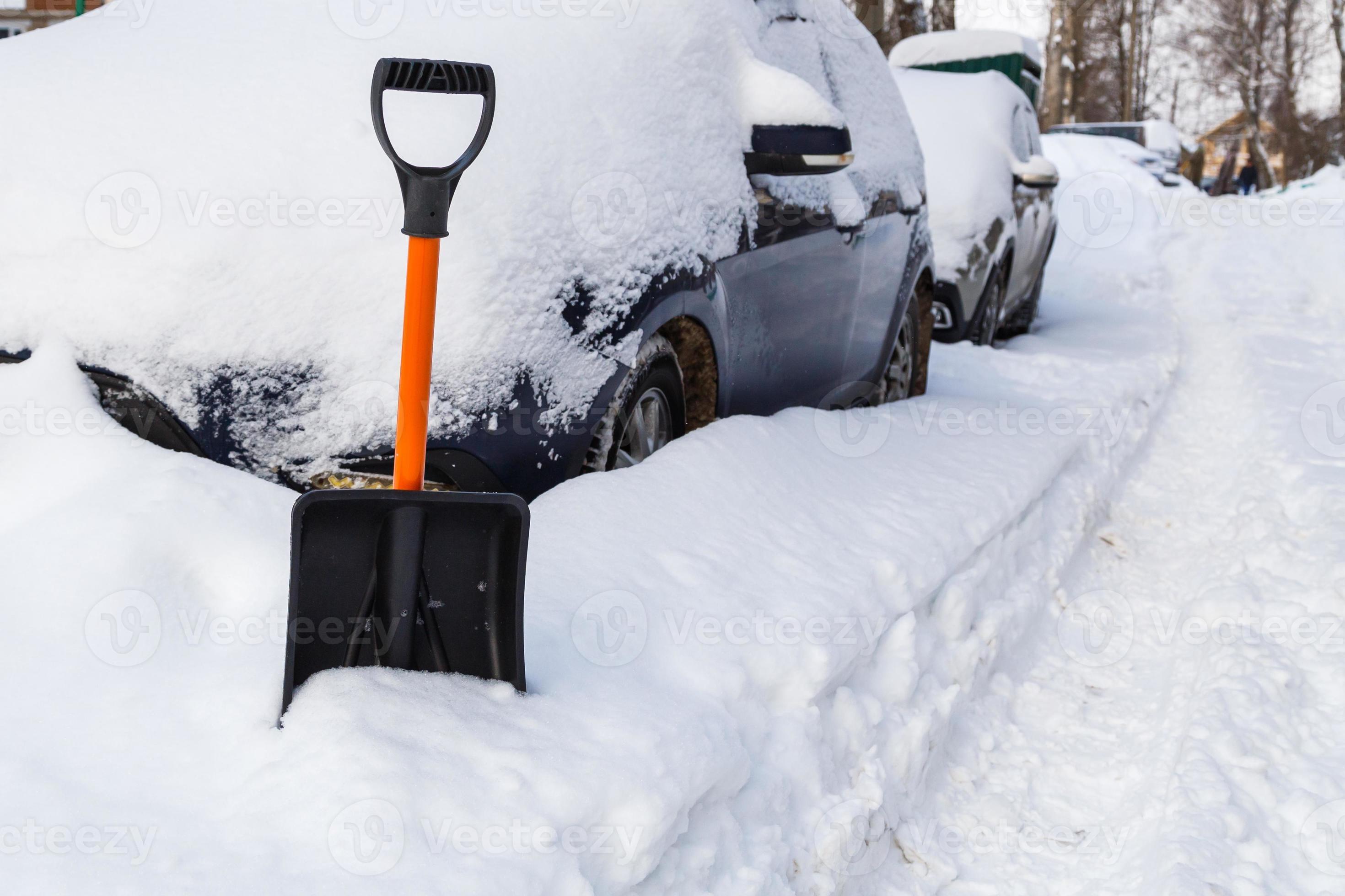 pelle à neige en plastique devant une voiture enneigée au matin d'hiver  ensoleillé 12633806 Photo de stock chez Vecteezy