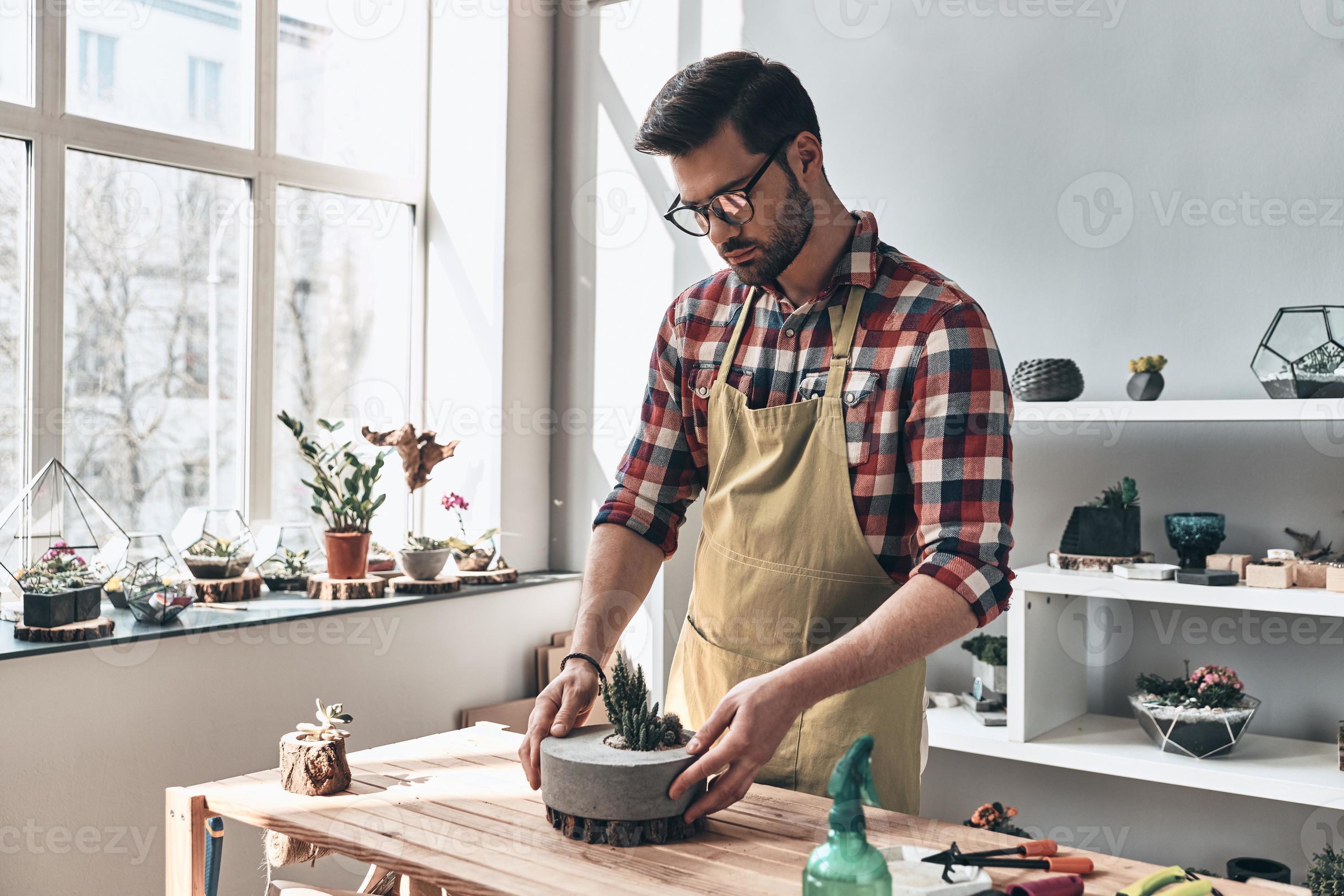 gourou du jardinage. beau jeune homme en tablier prenant soin de