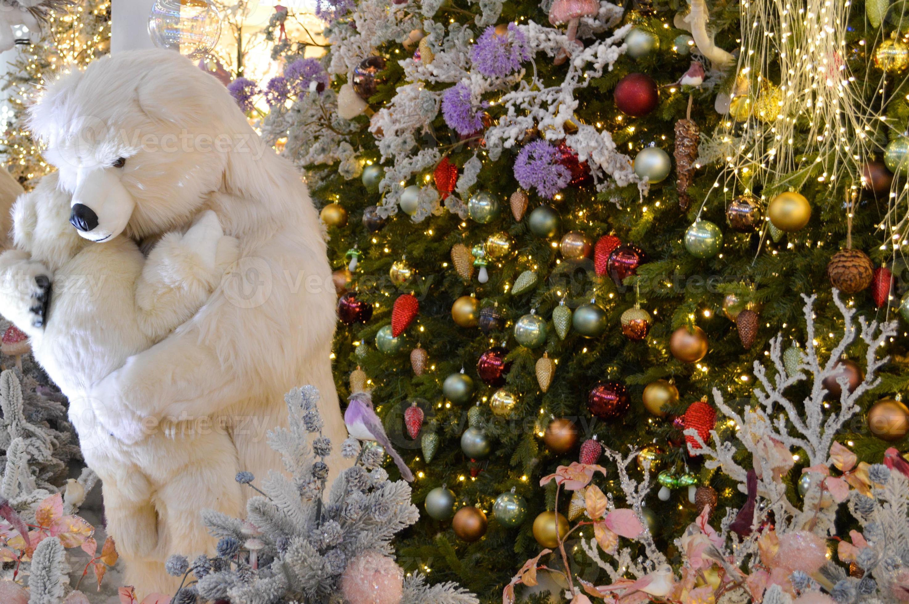 décoration de vitrine, décoration de centre commercial. épicéa blanc  artificiel avec guirlandes. à côté d'eux, un ours polaire en peluche  embrasse un ourson. joli paysage de noël 13681024 Photo de stock chez