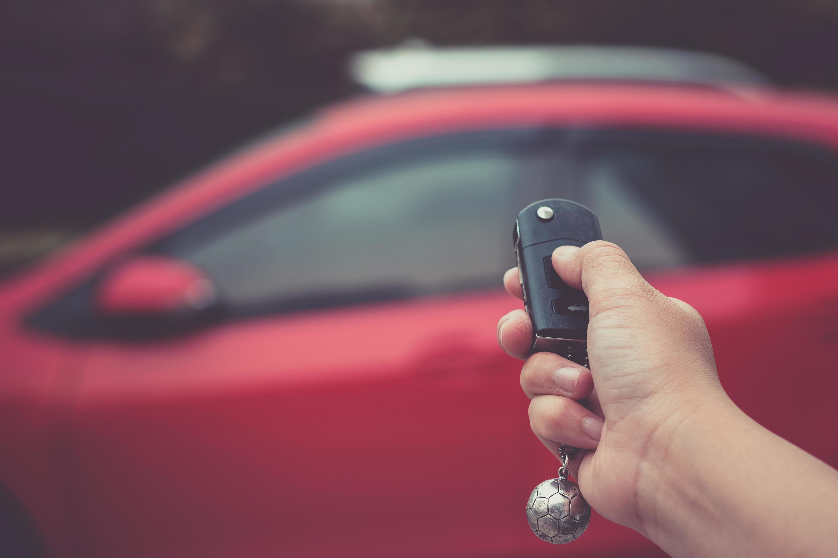 Homme poussant le bouton sur la clé de voiture de la télécommande