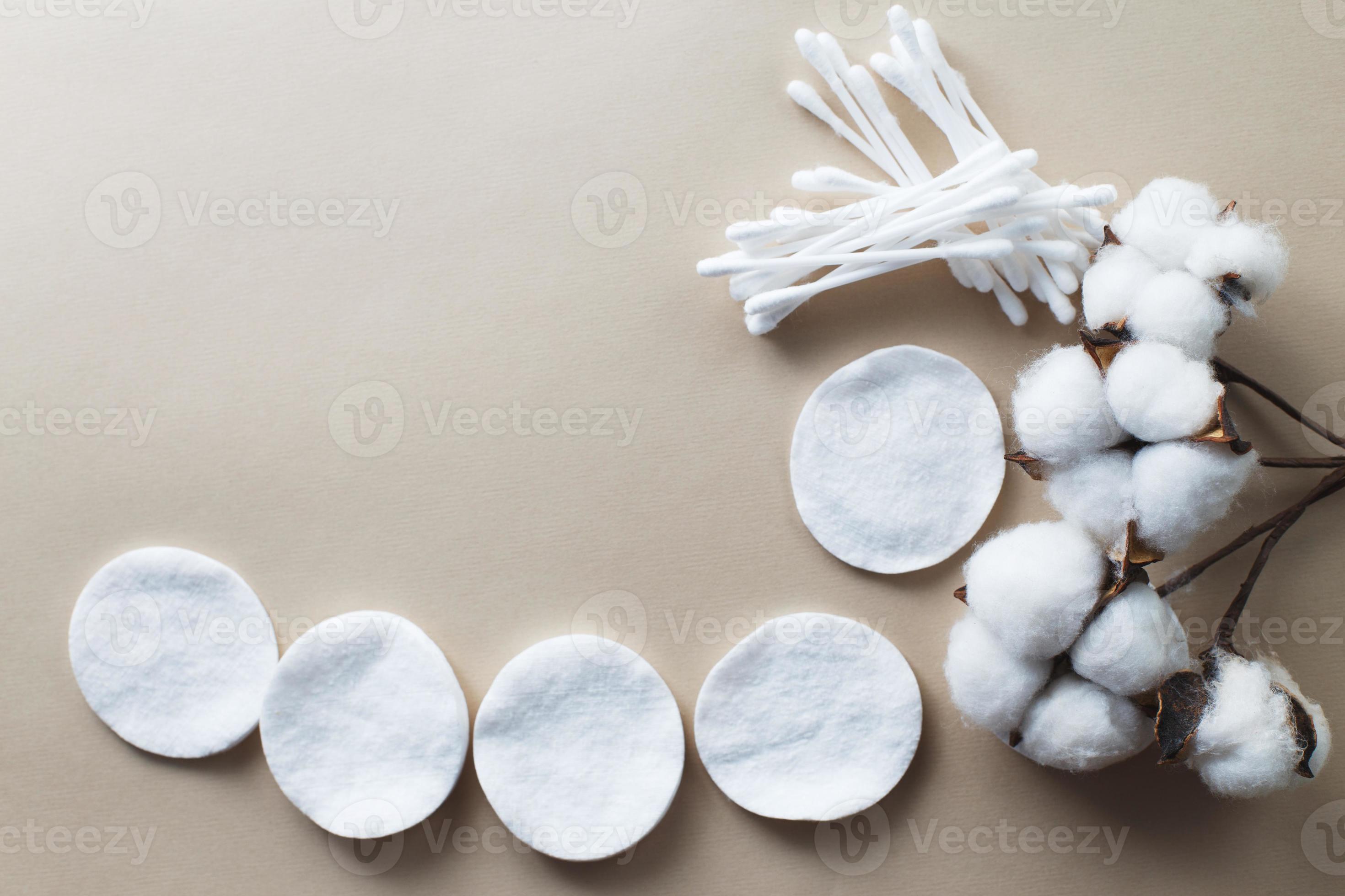 tampons de coton fleur de coton moelleux et cotons-tiges sur fond beige  avec espace de copie. produit jetable hygiénique 14001627 Photo de stock  chez Vecteezy