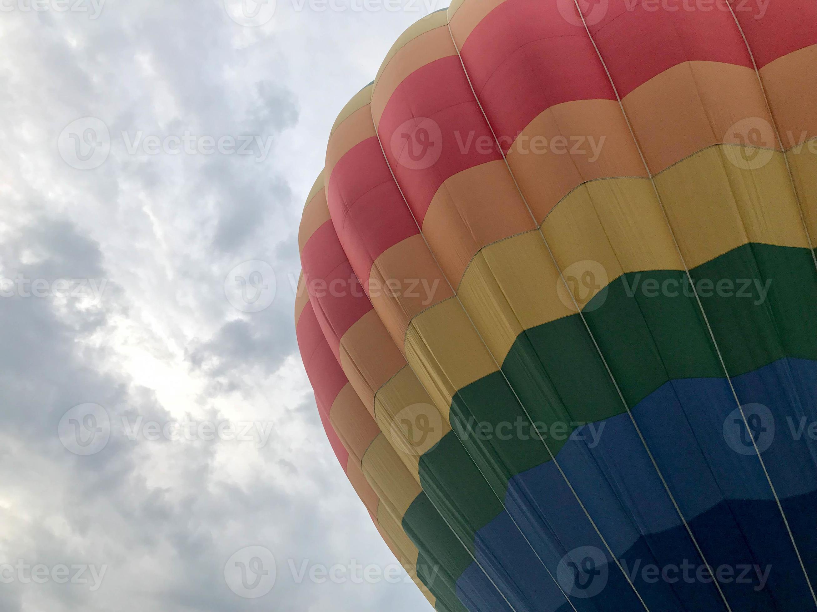 Grand ballon volant multicolore à rayures rondes et lumineuses de couleur  arc-en-ciel avec un panier contre le ciel le soir 14268810 Photo de stock  chez Vecteezy