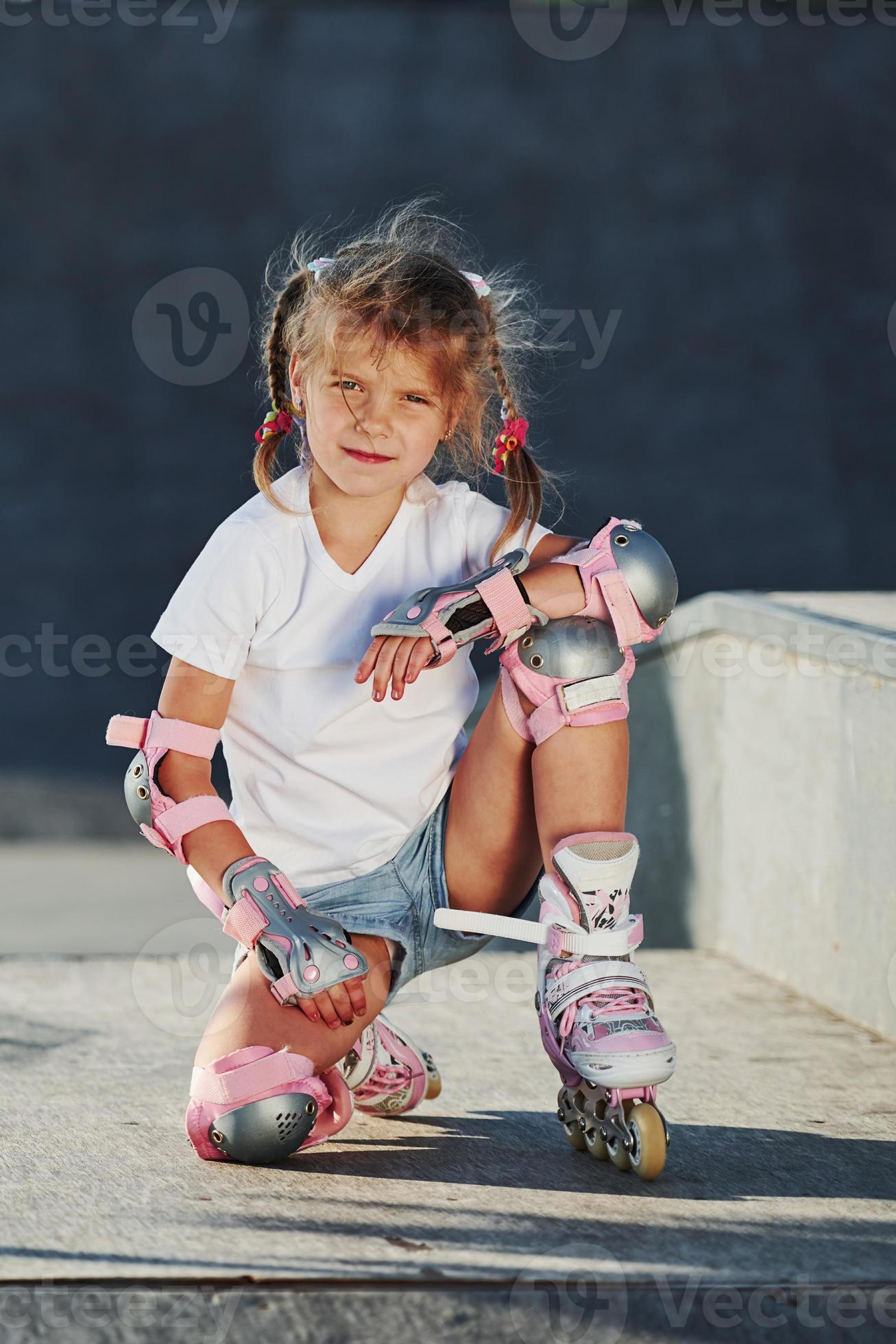 Une Jolie Petite Fille Apprend À Faire Du Patin À Roulettes. Un