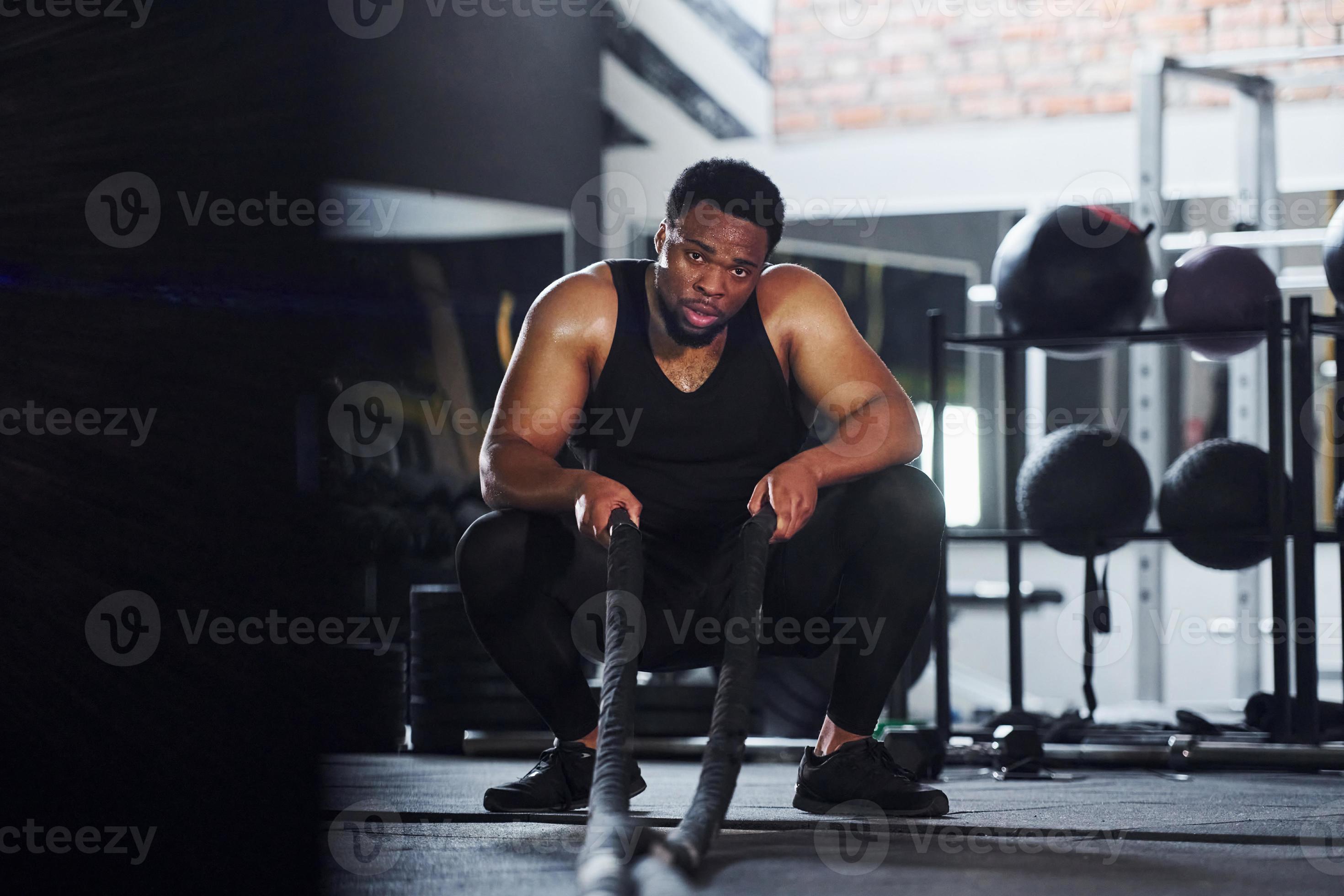 un homme afro-américain fort en vêtements sportifs a une journée  d'entraînement dans la salle de sport. faire du crossfit en utilisant des  cordes 15293921 Photo de stock chez Vecteezy