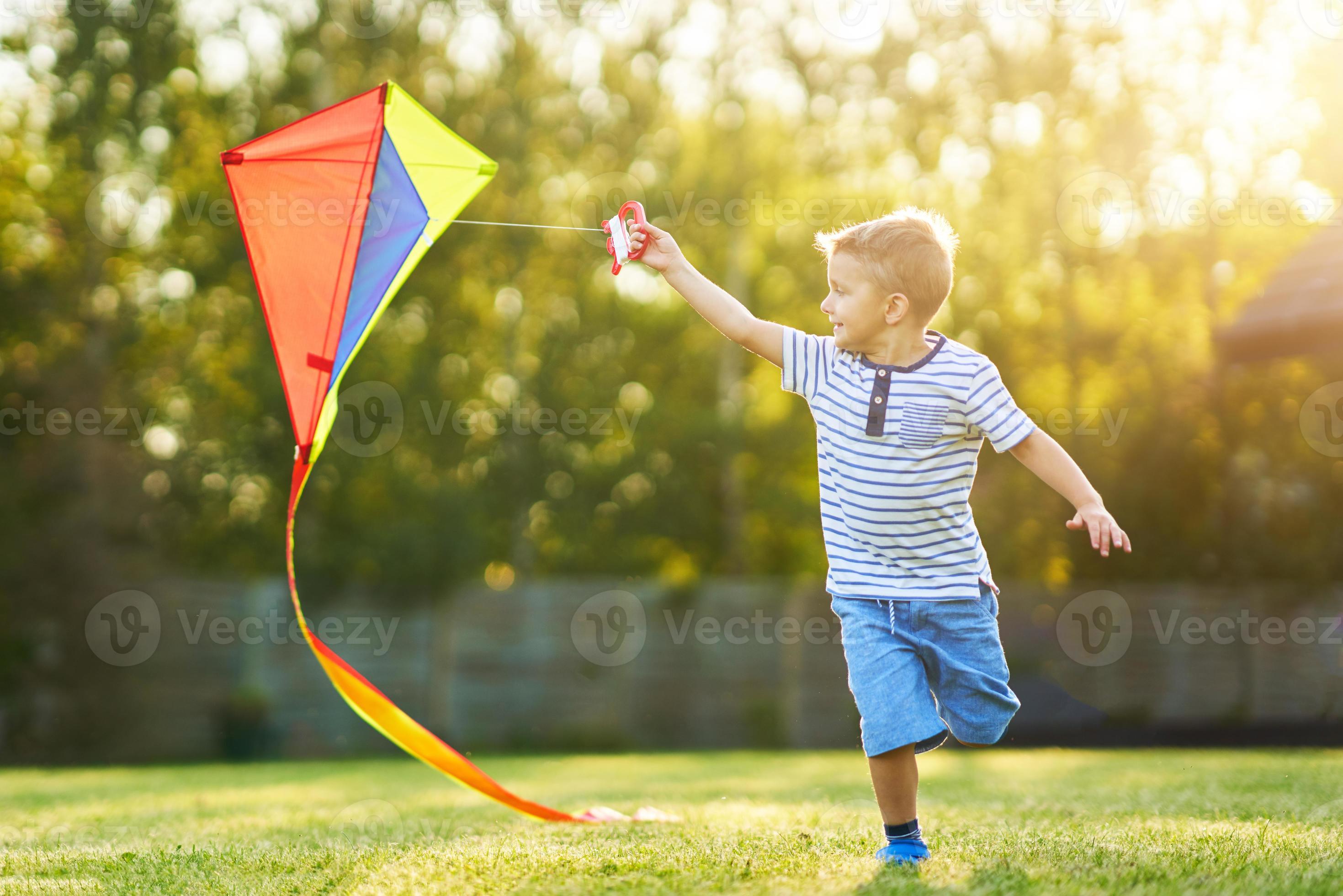 un enfant heureux lance un cerf-volant sur le terrain au coucher du soleil.  petit garçon et fille en vacances d'été 3673210 Photo de stock chez Vecteezy