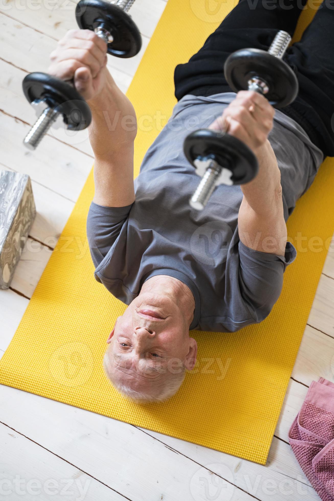homme âgé faisant de l'exercice avec des haltères pendant son entraînement  dans une salle de sport à domicile 16292850 Photo de stock chez Vecteezy
