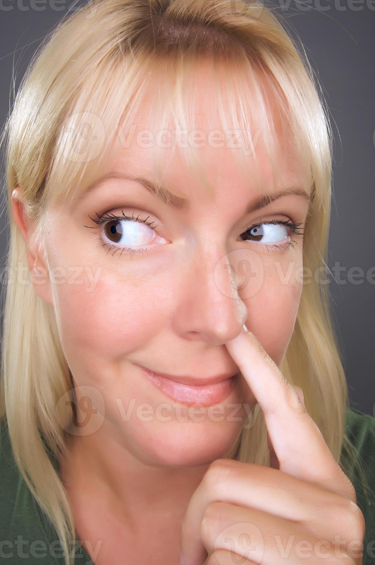 femme blonde avec un doigt dans le nez 16356432 Photo de stock chez Vecteezy