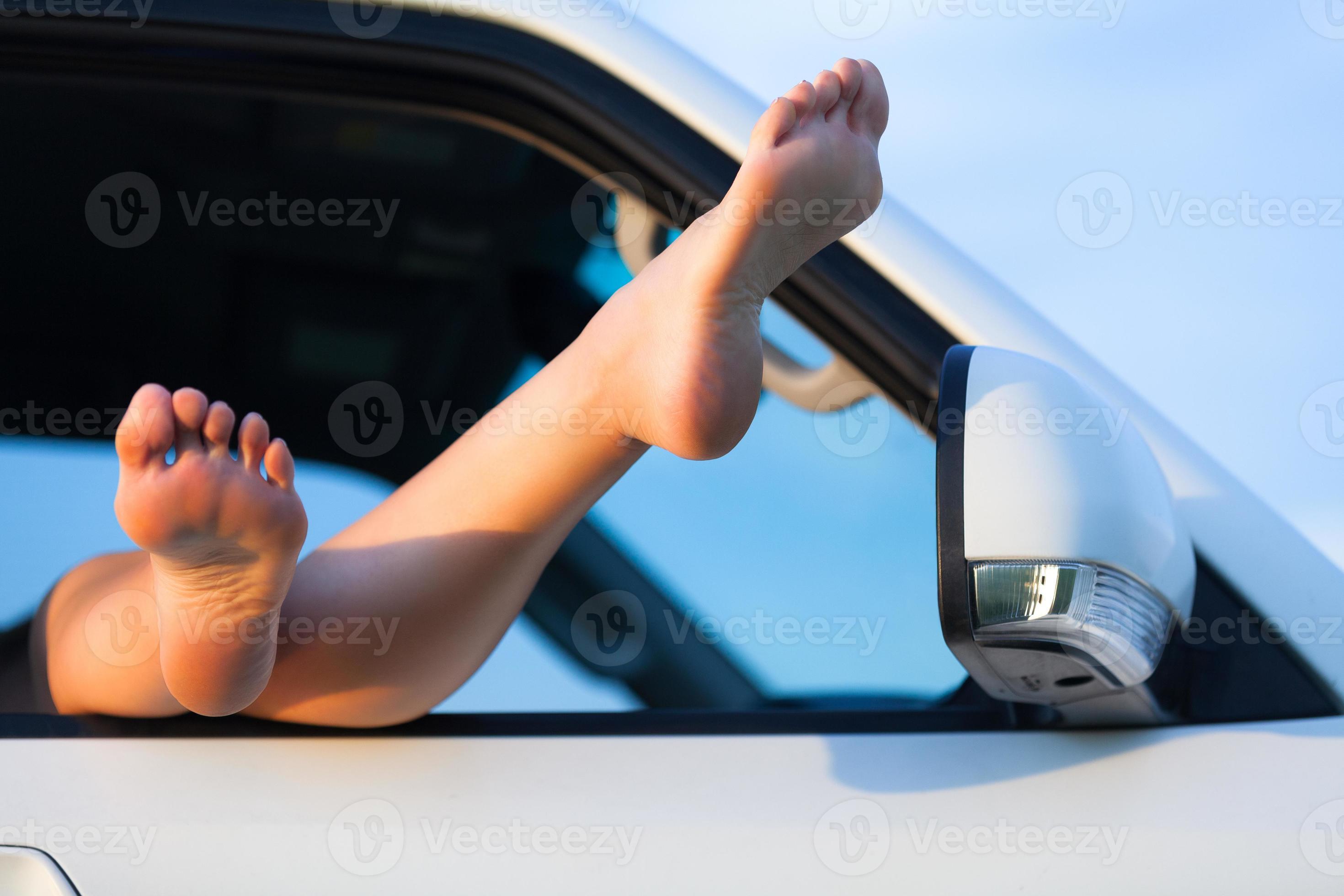 Jambes féminines se balançant à partir de la fenêtre de la voiture contre  la mer 14354129 Photo de stock chez Vecteezy