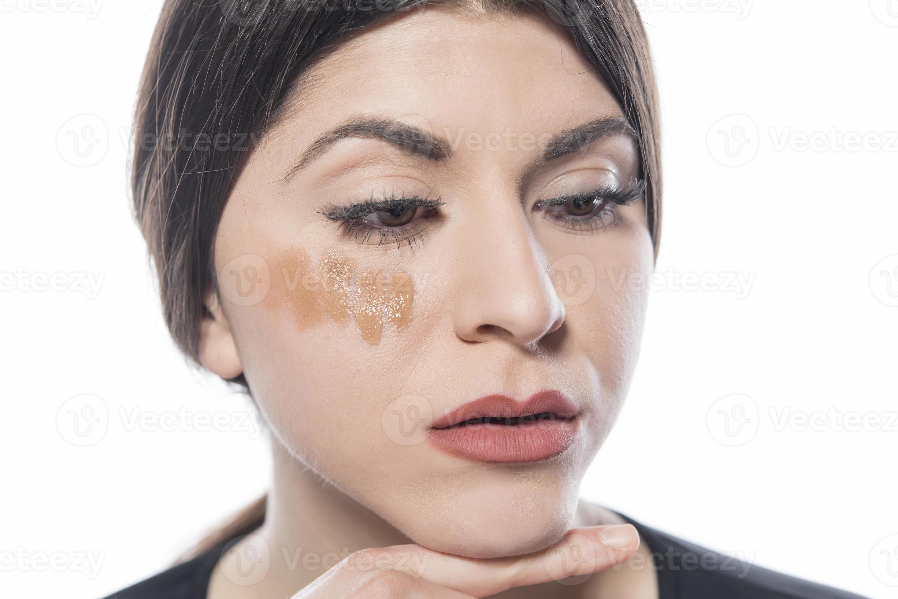 portrait d'une jeune femme appliquant un maquillage liquide sur son visage.  isolé sur fond blanc 16607135 Photo de stock chez Vecteezy